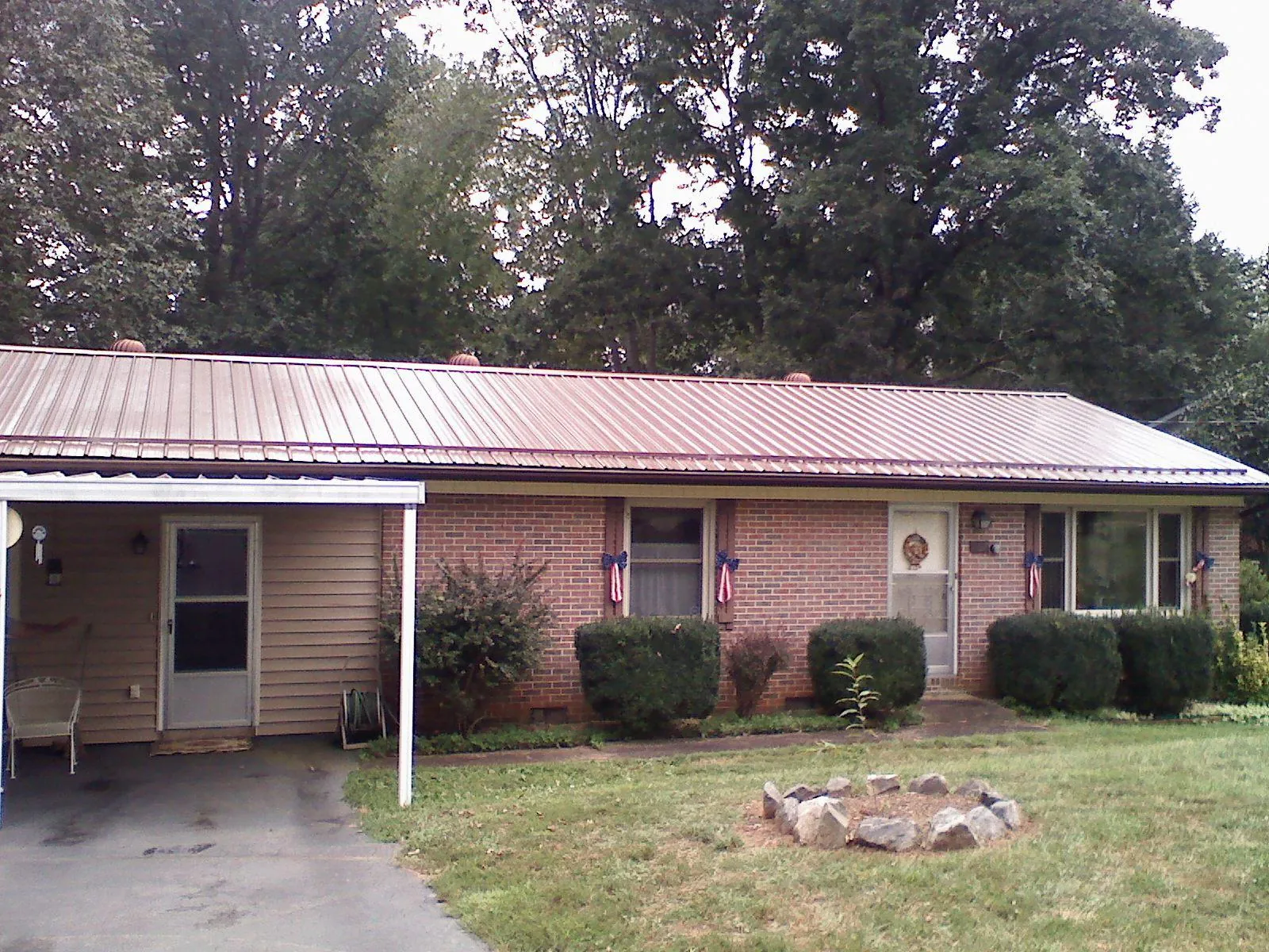 Bronze metal roof and carport on a brick ranch home — Roof Repair work by our crew in La Plume
